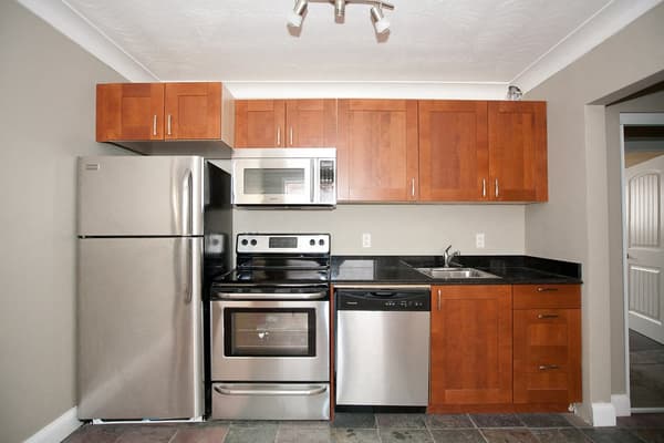 Kitchen with stainless steel appliances and wood cabinetry at 18 Elm Street, Kingston