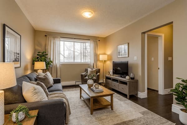 Living room with sofa, television and window at 18 Elm Street, Kingston, shown virtually staged