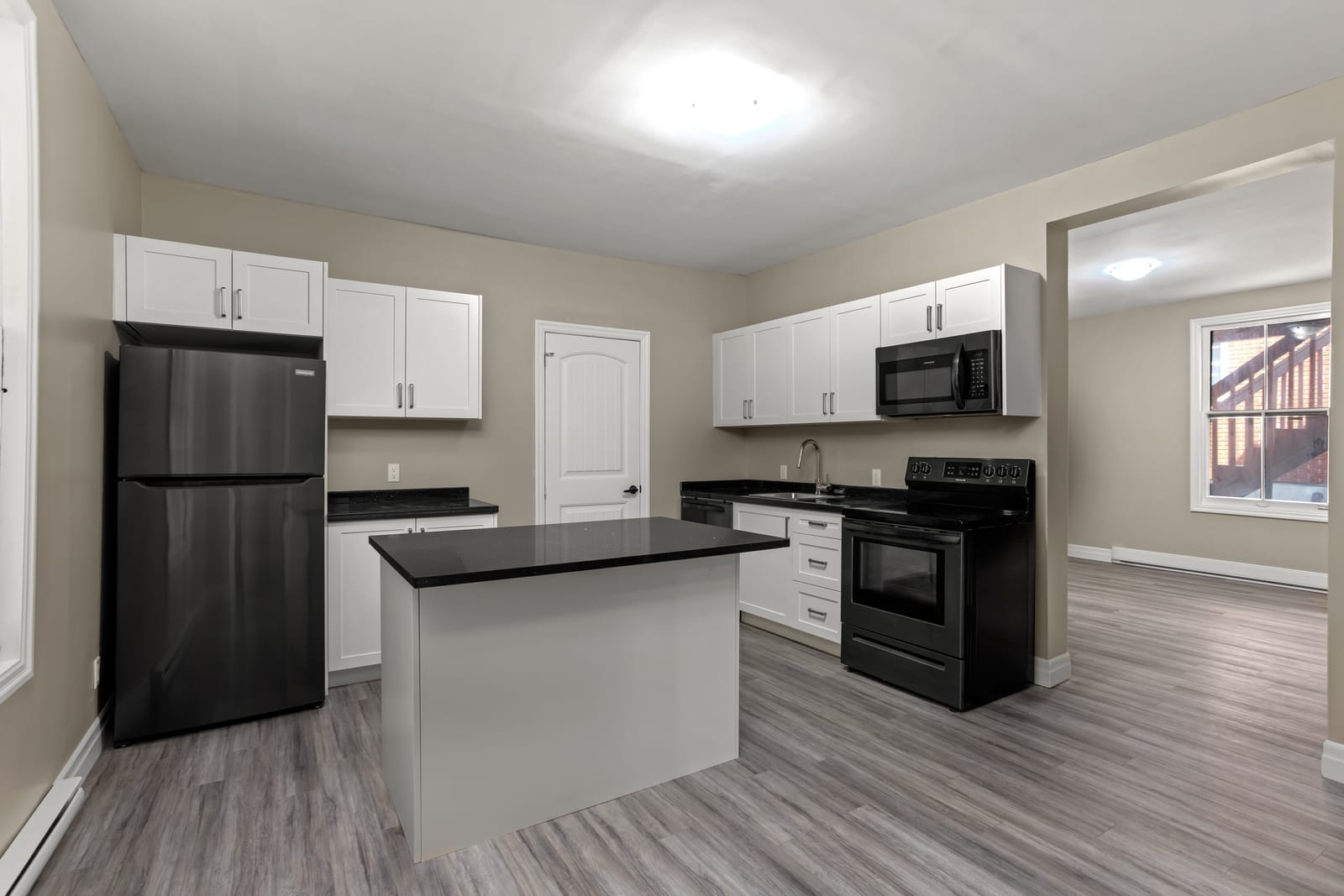 Renovated kitchen with a black quartz island at 203 Colborne Street