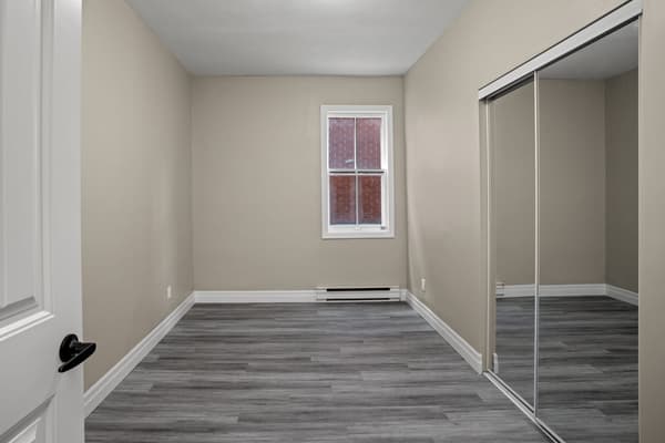 Bedroom with a mirrored sliding closet at 203 Colborne Street, Kingston