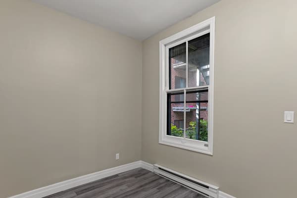 Bedroom with a tall double-hung window at 203 Colborne Street, Kingston