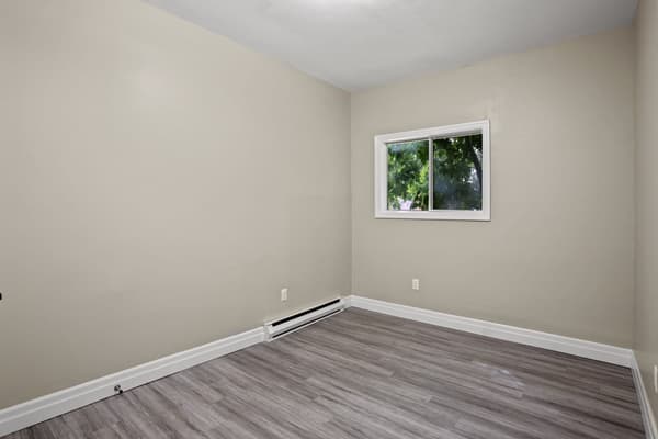 Bedroom with a wide window over the trees at 203 Colborne Street, Kingston