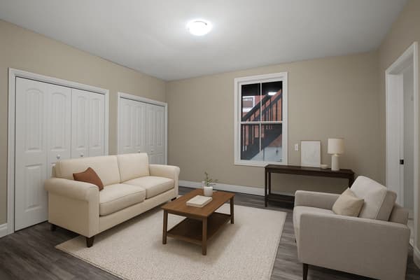 Living room with a sofa, armchair and console table at 203 Colborne Street, Kingston, shown virtually staged