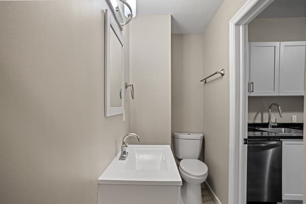 Powder room with a vanity and mirror, open to the kitchen at 203 Colborne Street, Kingston