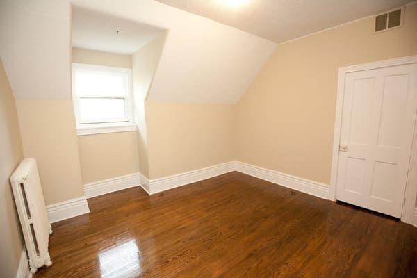 Top floor bedroom with a dormer window and a cast iron radiator at 353 Alfred Street, Kingston