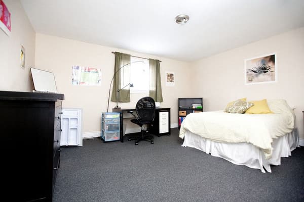 Bedroom with a study desk, dresser and bar fridge at 353 Alfred Street, Kingston