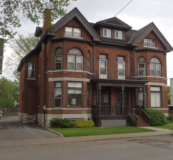 Red brick heritage exterior with bay windows and a covered front porch at 353 Alfred Street, Kingston